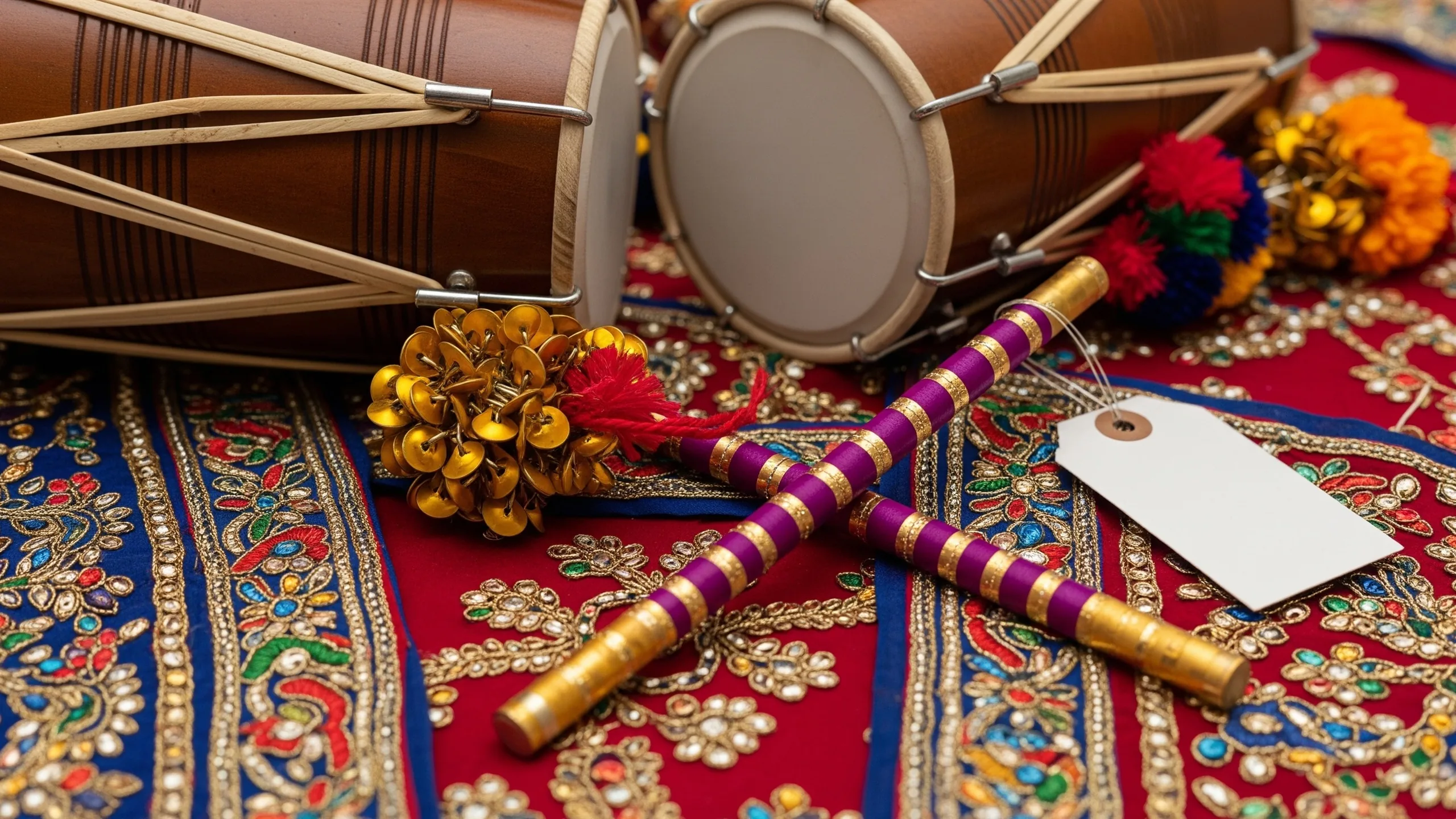 A close detail of dhol, ghungroo, dandiya sticks and embroidered performance dupattas on rich fabric, no tags, close-up detail